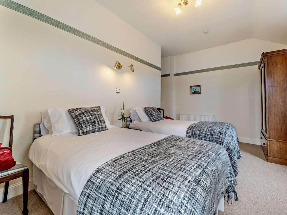 A bedroom with two beds and a dresser at Dunoon Sleeps 17 Group Retreat with Parking in Kirn near Dunoon