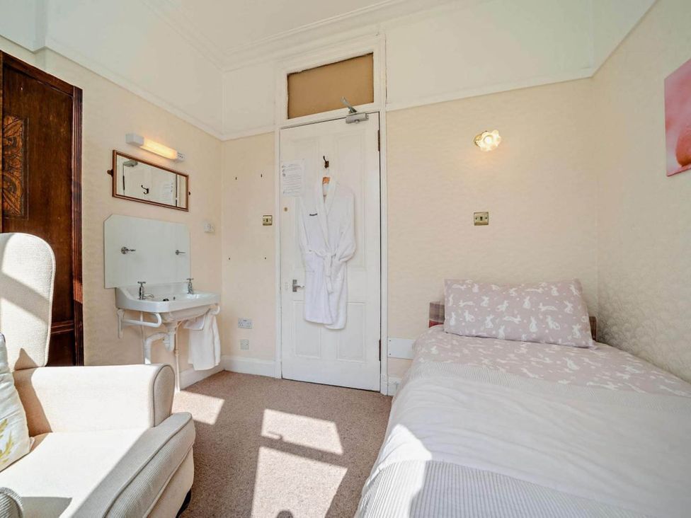 A bedroom with a bed and chair at Dunoon Sleeps 17 Group Retreat with Parking in Kirn near Dunoon