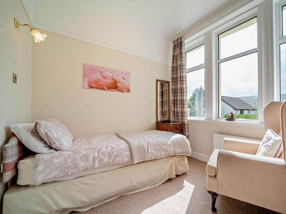 A bedroom with a bed and an armchair at Dunoon Sleeps 17 Group Retreat with Parking in Kirn near Dunoon