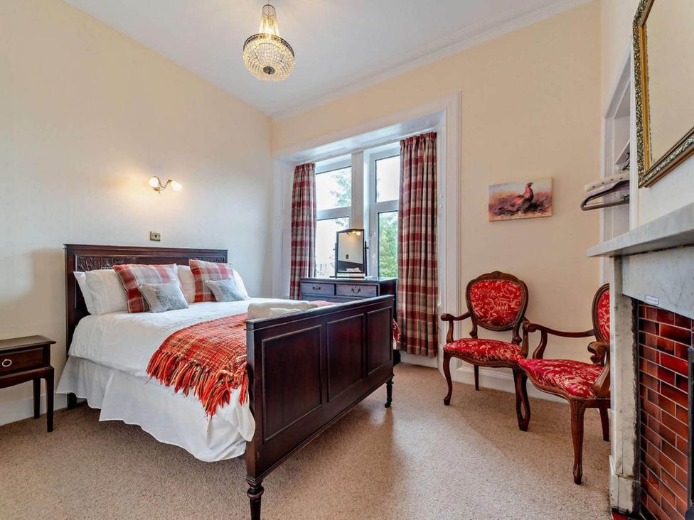 A bedroom with a bed and chairs at Dunoon Sleeps 17 Group Retreat with Parking Kirn near Dunoon