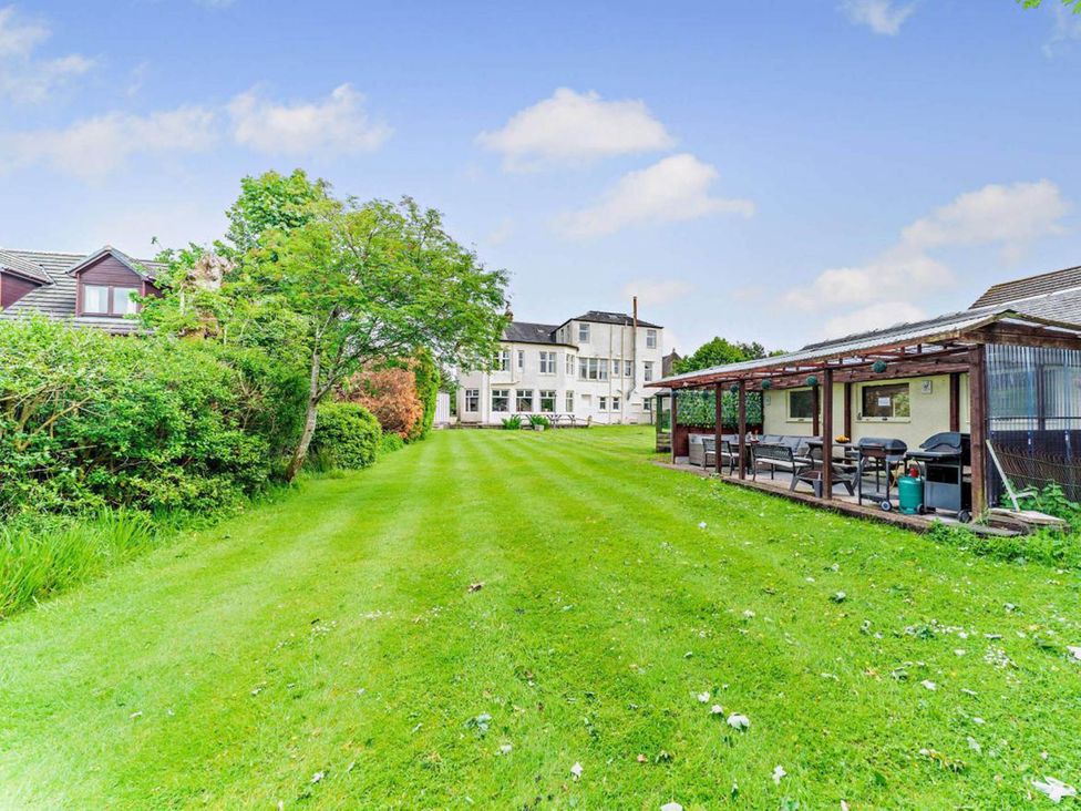 A garden with a tree and building at Dunoon Sleeps 17 Group Retreat with Parking in Kirn near Dunoon