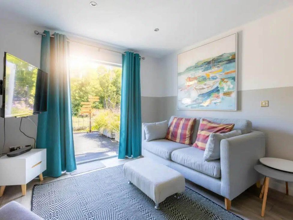 A living room with a television and sofa at 2 Bedrooms overlooking Little Petherick Creek in Little Petherick