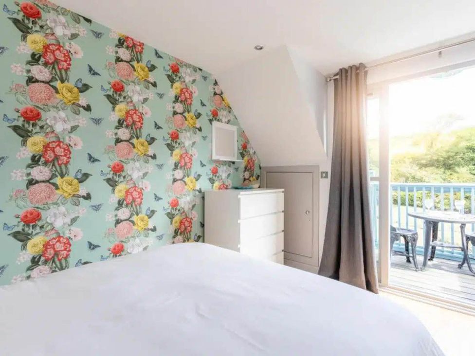 A bedroom with floral wallpaper and a dresser at 2 Bedrooms overlooking Little Petherick Creek in Little Petherick
