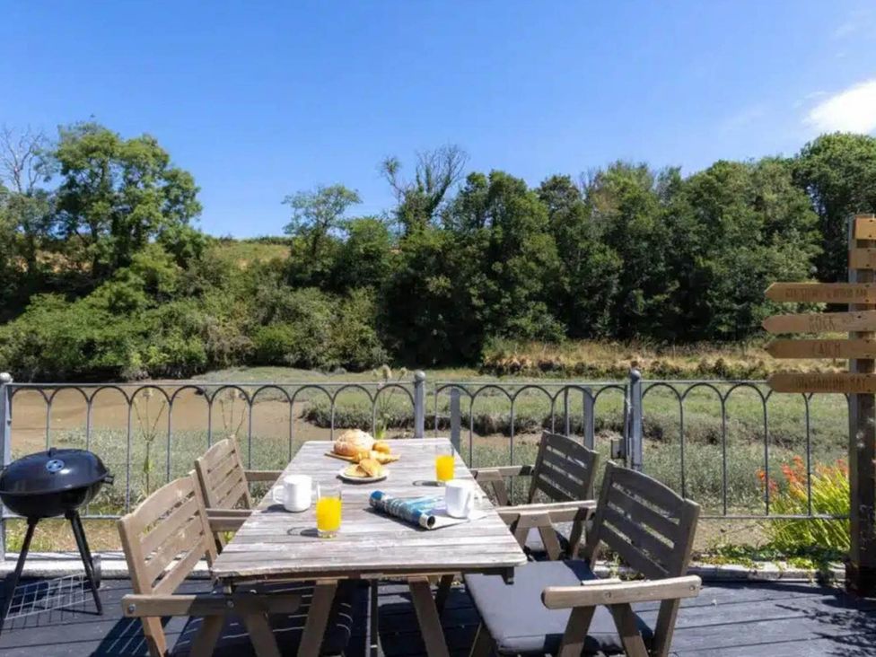 An outdoor seating area with a table and chairs at 2 Bedrooms overlooking Little Petherick Creek Little Petherick