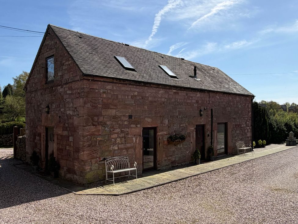 A stone building with windows and a bench at a property in Whiston near Cheadle