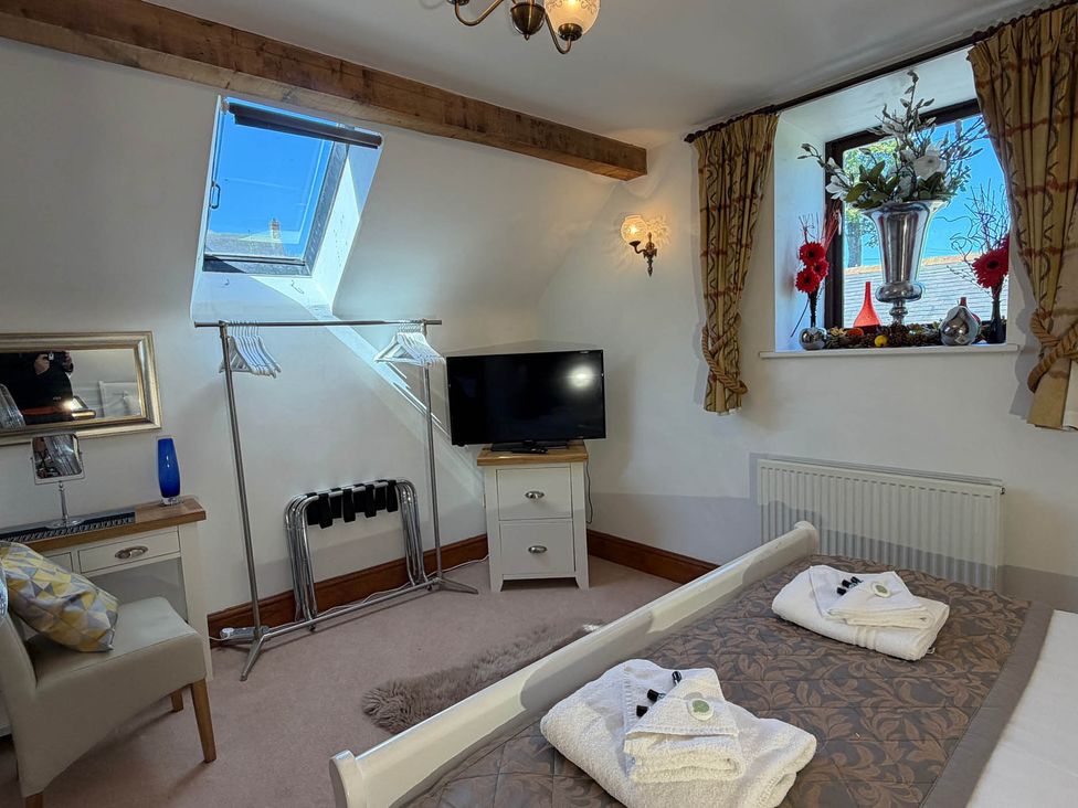 A bedroom with a bed and television at The Old Barn in Whiston near Cheadle