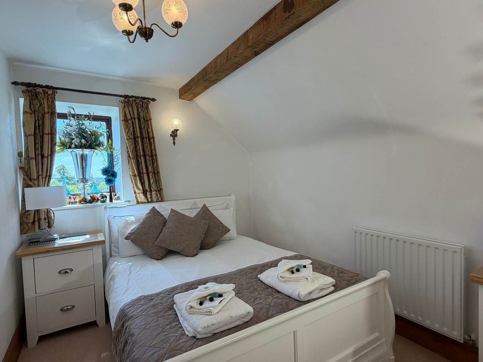 A bedroom with a bed and nightstand at The Old Barn in Whiston near Cheadle
