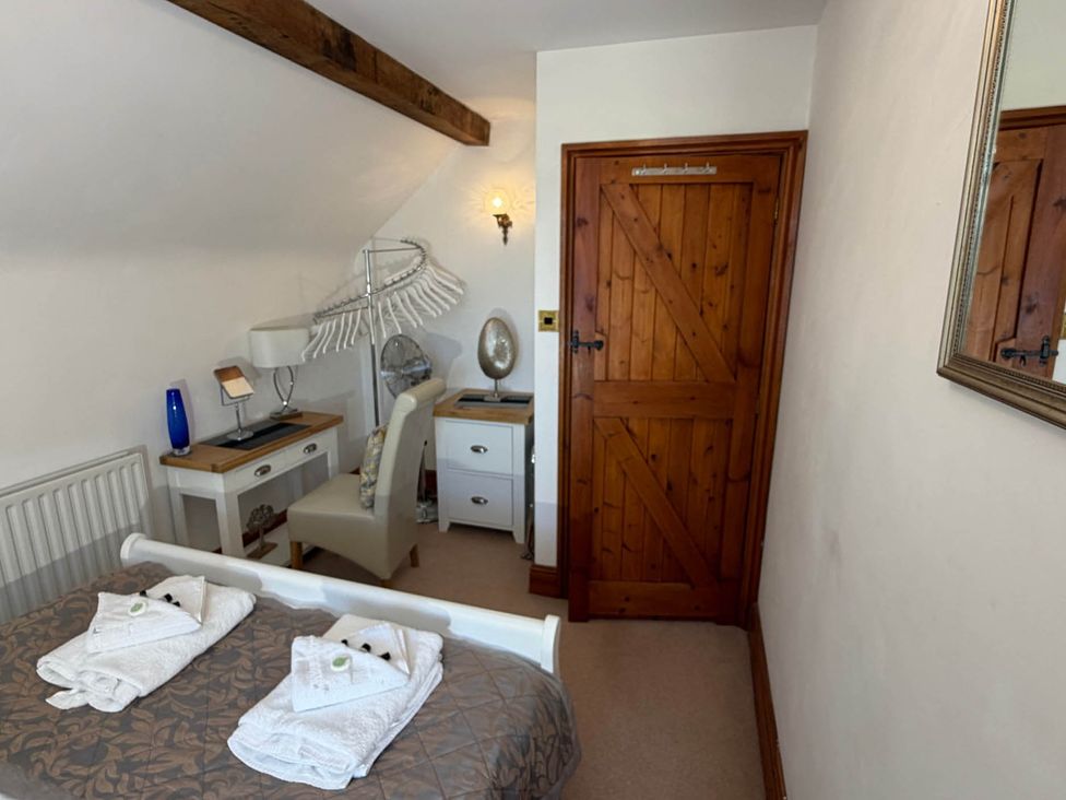 A bedroom with towels on the bed at The Old Barn in Whiston near Cheadle