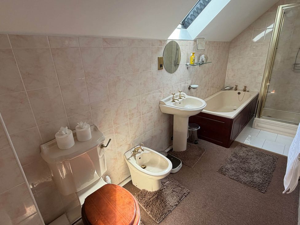 A bathroom with a toilet, sink, bathtub, and shower at property in Whiston near Cheadle