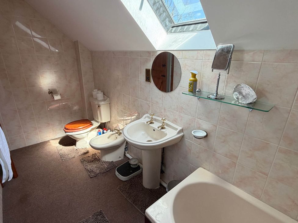 A bathroom with a sink, toilet, and bathtub at The Old Barn in Whiston near Cheadle
