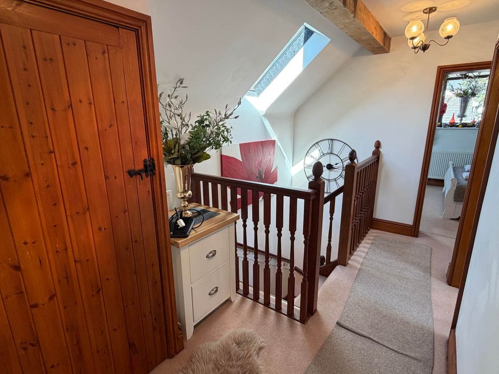 A hallway with a staircase and decorative elements at The Old Barn in Whiston near Cheadle