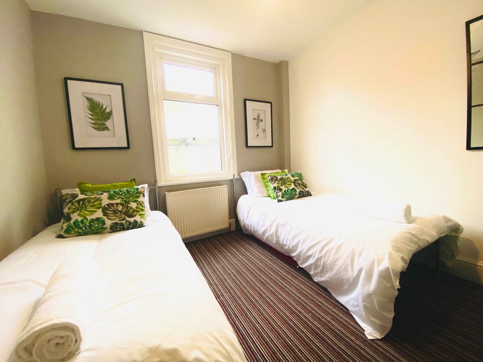 A bedroom with two beds and a window at Blackpool 4 Beds Sleeps 10 Pet Friendly, Blackpool