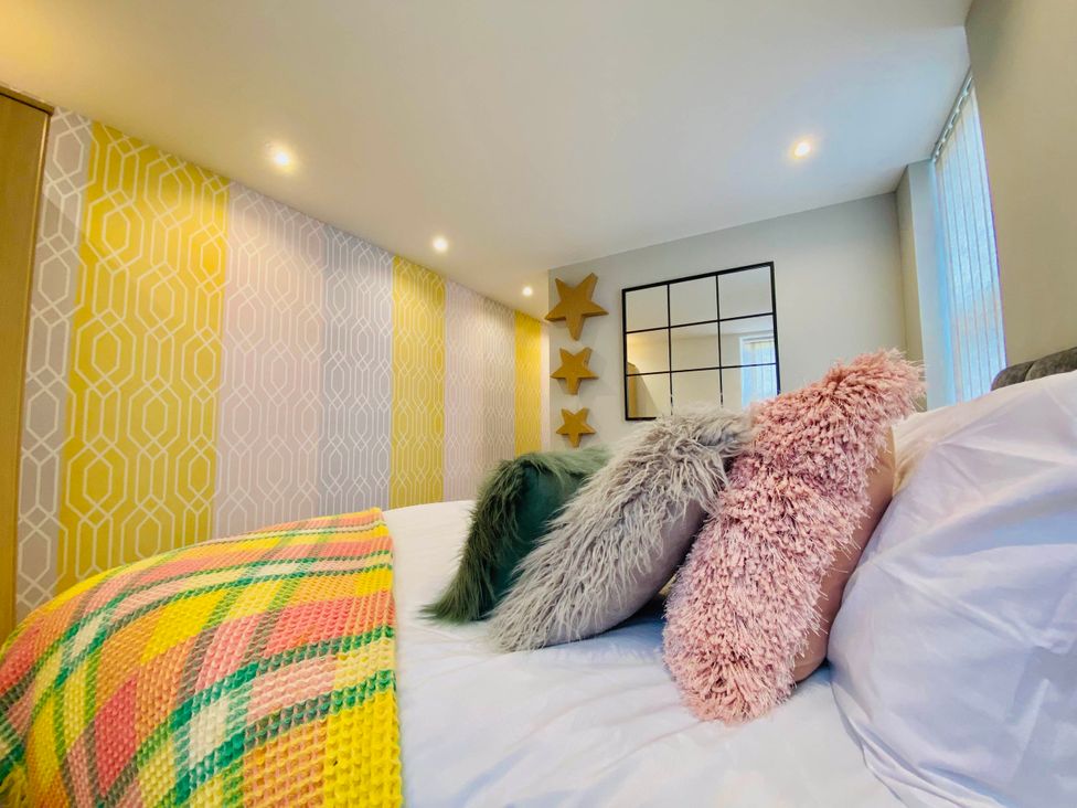 A bedroom with decorative pillows on a bed at Blackpool 4 Beds Sleeps 10 Pet Friendly in Blackpool