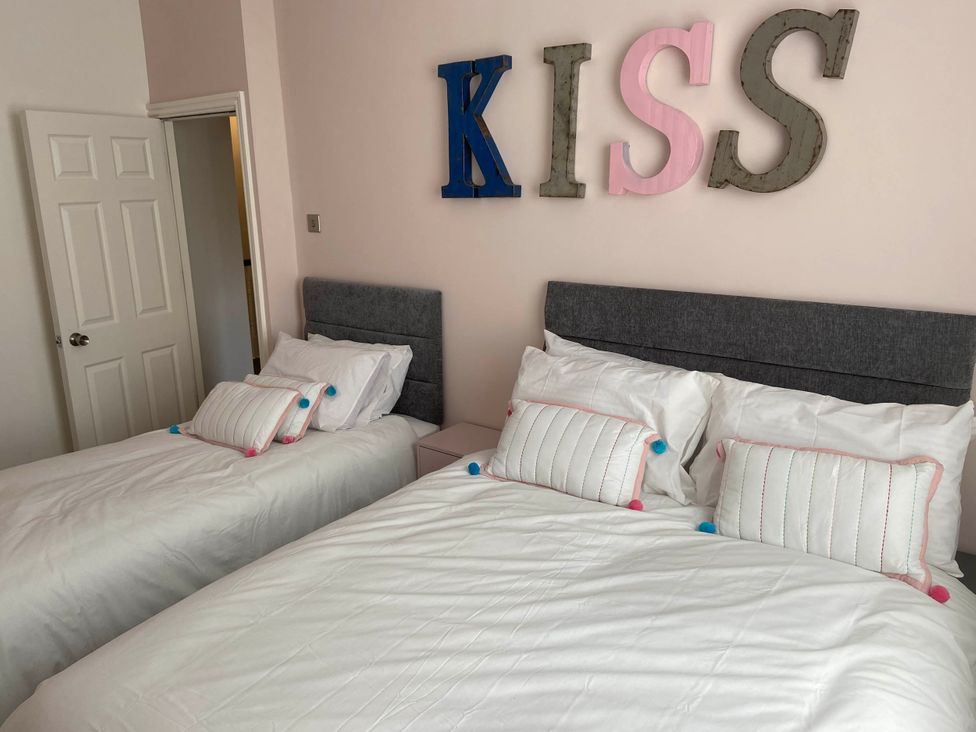 A bedroom with two beds and decorative cushions at Blackpool 4 Beds Sleeps 10 Pet Friendly in Blackpool