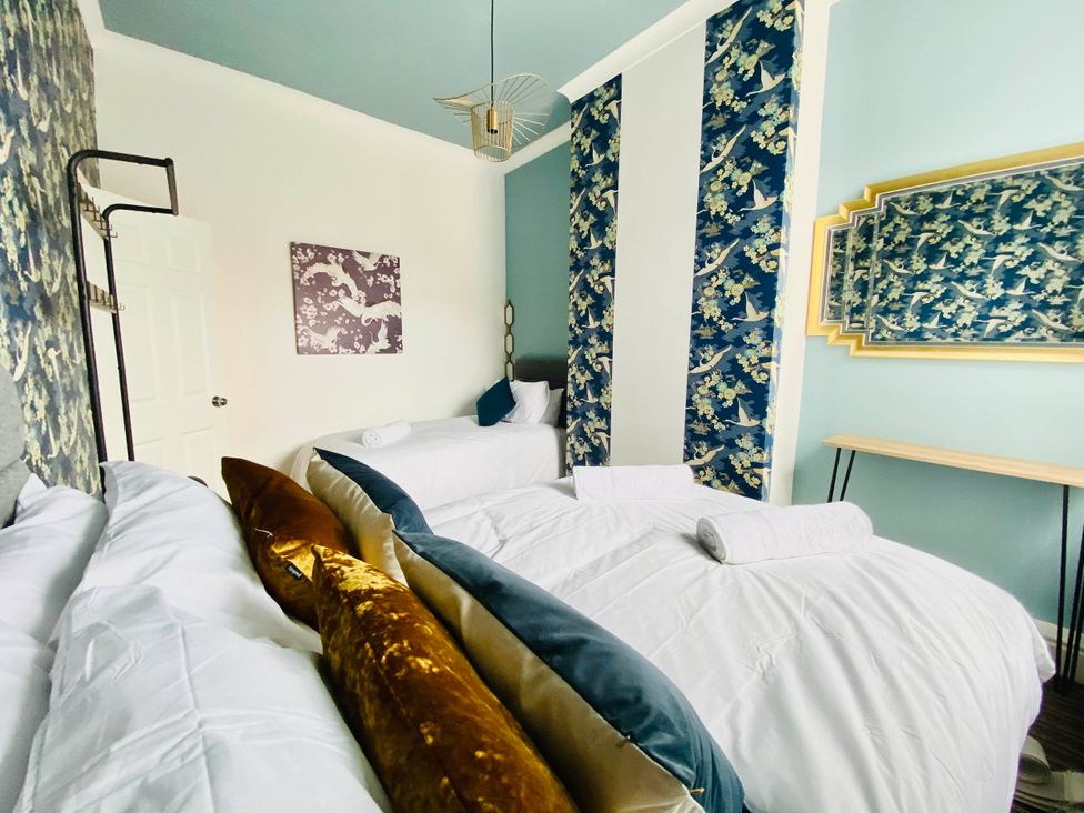A bedroom with beds, towels, and a mirror at Blackpool 4 Beds Sleeps 10 Pet Friendly in Blackpool