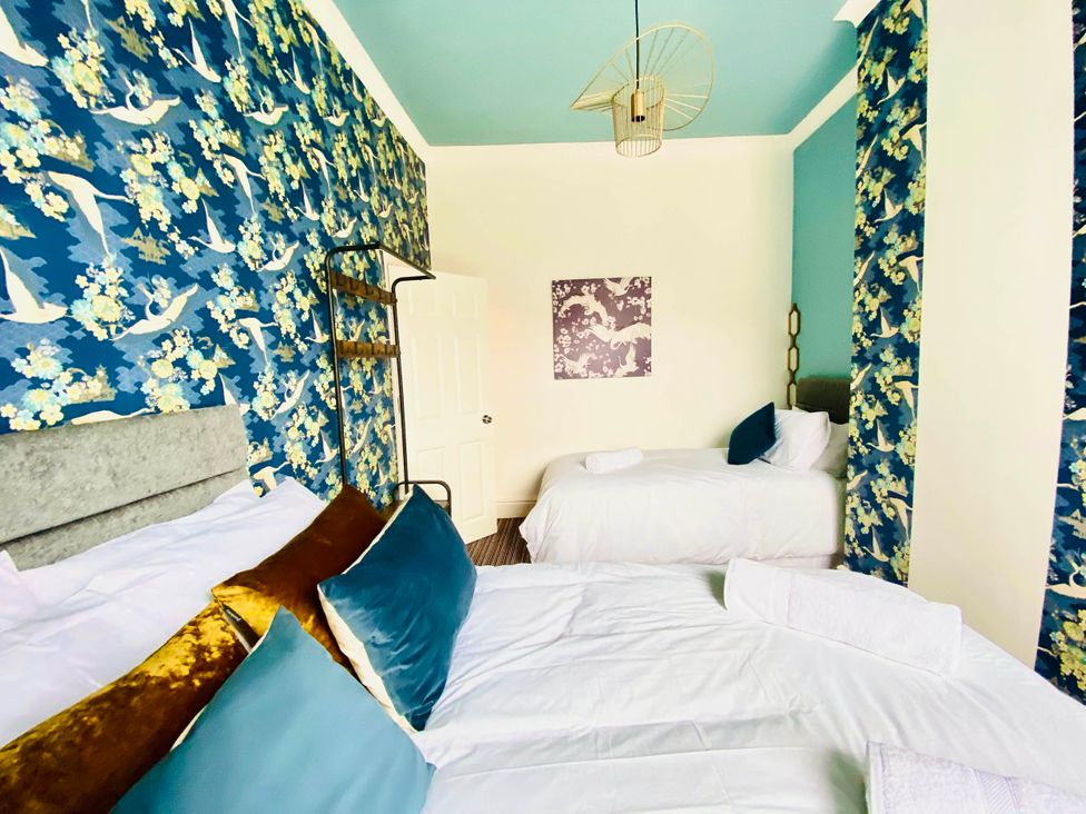 A bedroom with two beds and decorative wallpaper at Blackpool 4 Beds Sleeps 10 Pet Friendly in Blackpool