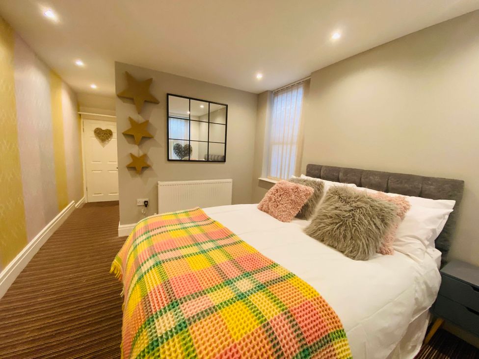 A bedroom with a bed and decorative pillows at Blackpool 4 Beds Sleeps 10 Pet Friendly in Blackpool