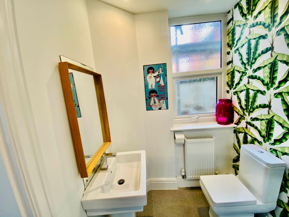 A bathroom with a sink, toilet, and window at Blackpool 4 Beds Sleeps 10 Pet Friendly in Blackpool