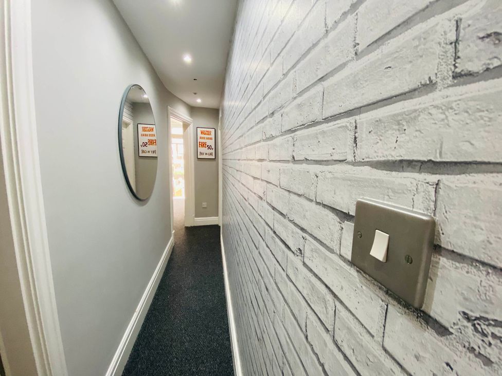 A hallway with a mirror and light switch at Blackpool 4 Beds Sleeps 10 Pet Friendly in Blackpool