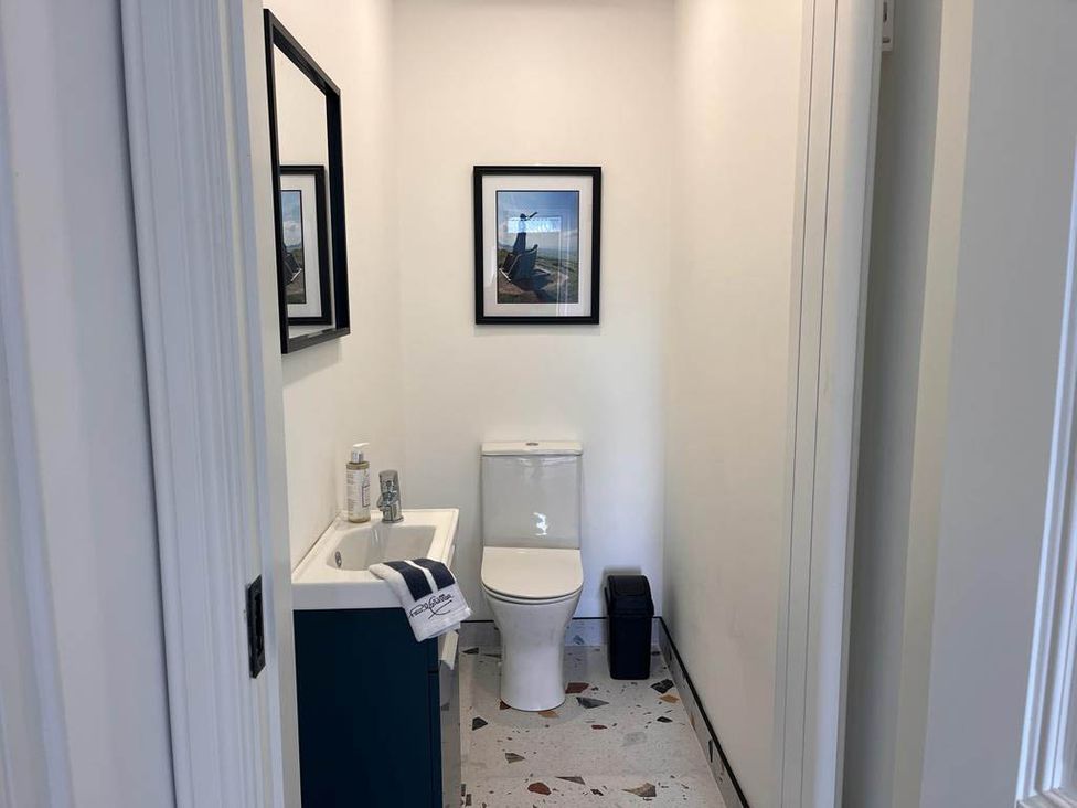 A bathroom with a toilet and sink at Sunset Cottage Sleeps 6 with Parking Garden Magilligan near Limavady