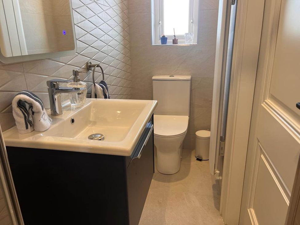 A bathroom with a sink and toilet at Sunset Cottage Sleeps 6 with Parking Garden Magilligan near Limavady