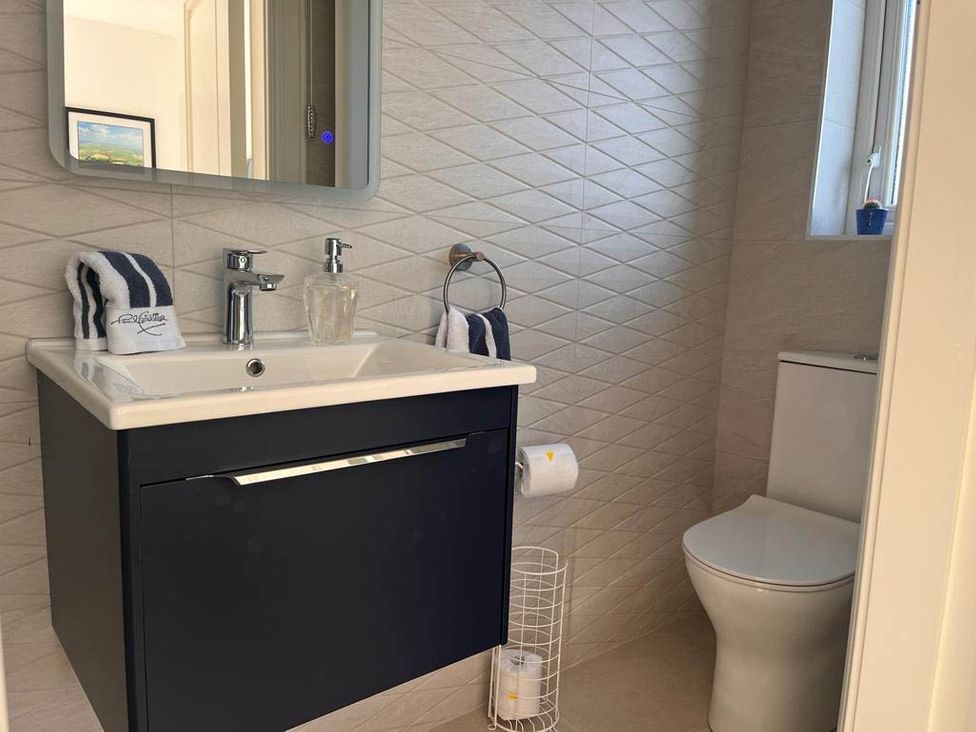A bathroom with sink and toilet at Sunset Cottage Sleeps 6 with Parking Garden in Magilligan near Limavady