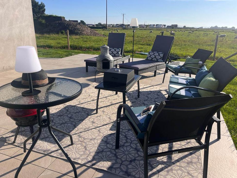 A seating area with chairs and table at Sunset Cottage Sleeps 6 with Parking Garden in Magilligan near Limavady