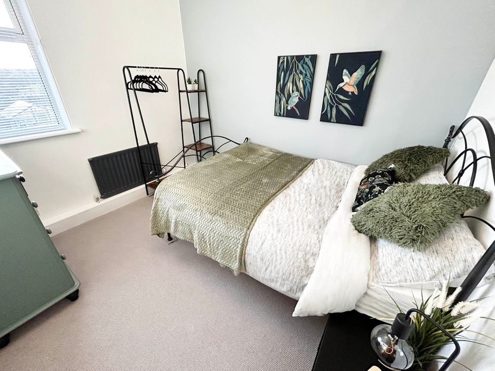 A bedroom with a bed and clothes rack at 6 Guests 3Bed House in Chester-Le-Street