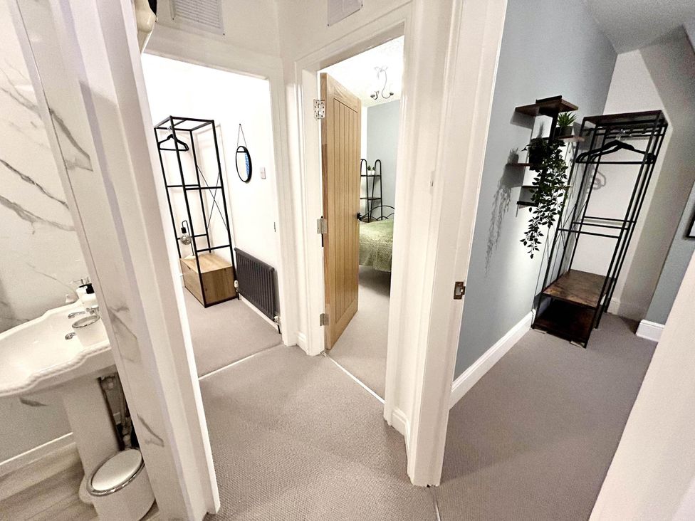 A hallway with a sink and doors to bedrooms at 6 Guests 3Bed House in Chester le Street