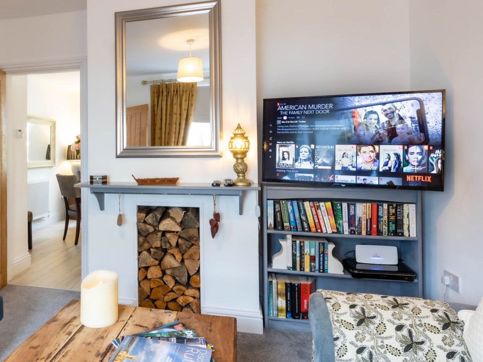 A living room with a tv and bookshelf at Cozy Nook boutique Cottage in Oakham