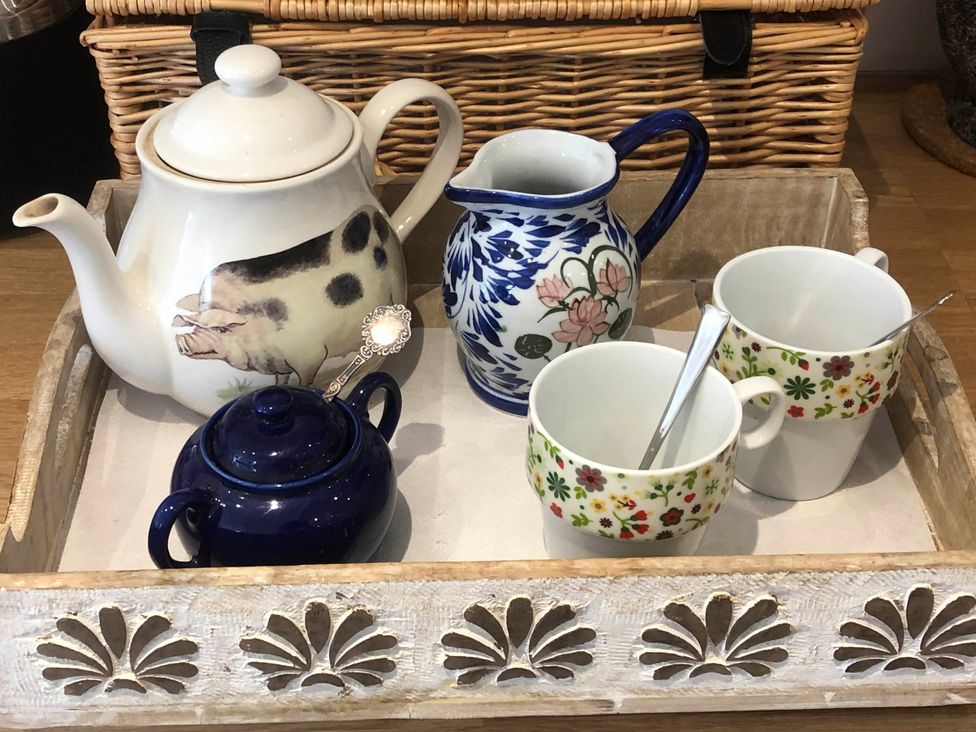 A teapot, milk jug, sugar bowl, and cups on a tray at Cozy Nook boutique Cottage in Oakham