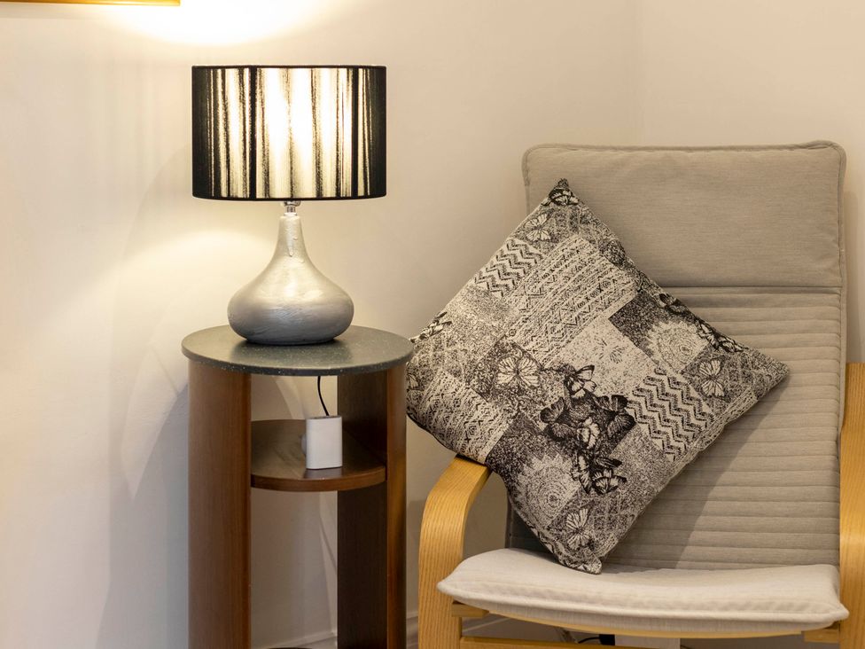 A living room with a lamp and a chair at Cozy Nook boutique Cottage in Oakham