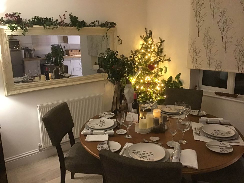 A dining room with a decorated table and Christmas tree at Cozy Nook boutique Cottage in Oakham