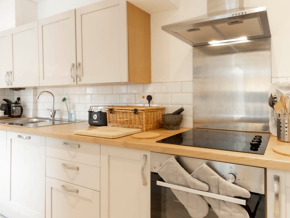 A kitchen with cabinets, sink, and stove at Cozy Nook boutique Cottage in Oakham