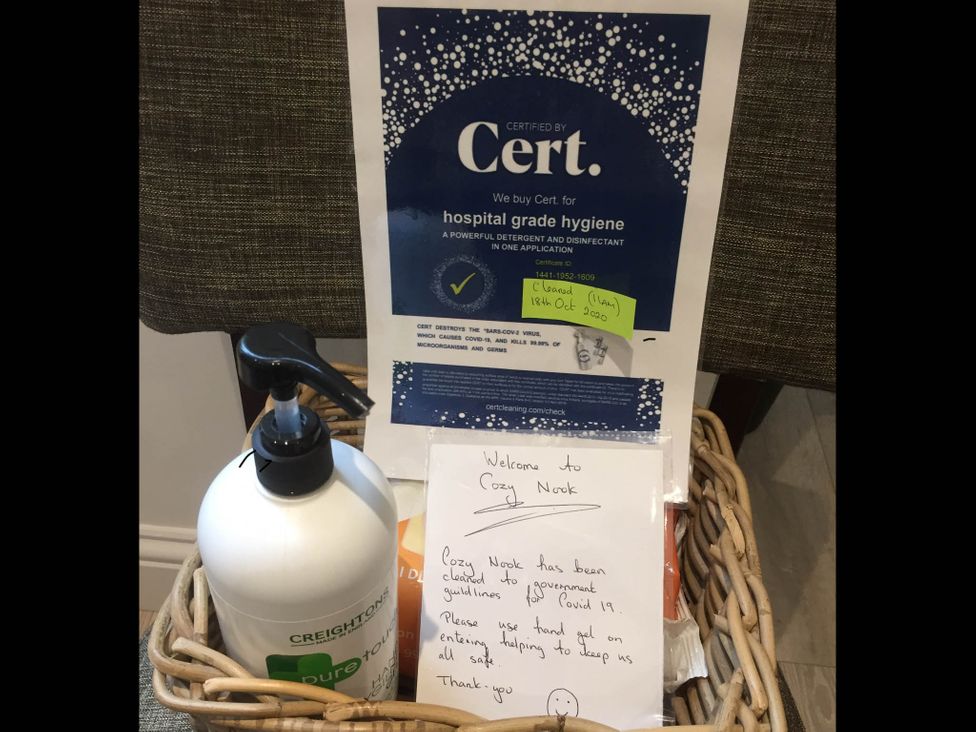 A basket with hand sanitizer and a welcome note at Cozy Nook boutique Cottage in Oakham