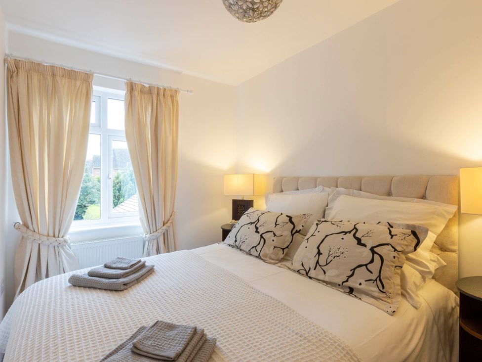 A bedroom with a bed and bedside lamps at Cozy Nook boutique Cottage in Oakham