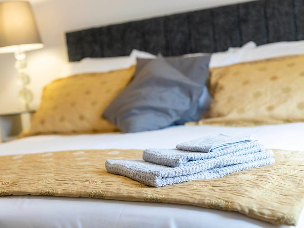 A bedroom with a bed and towels at Cozy Nook boutique Cottage in Oakham