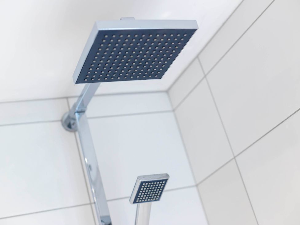 A shower head in a bathroom at Cozy Nook boutique Cottage in Oakham