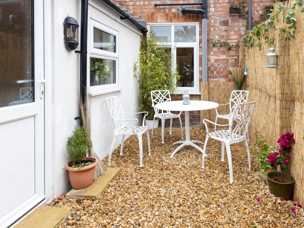 A garden with a table and chairs at Cozy Nook boutique Cottage in Oakham