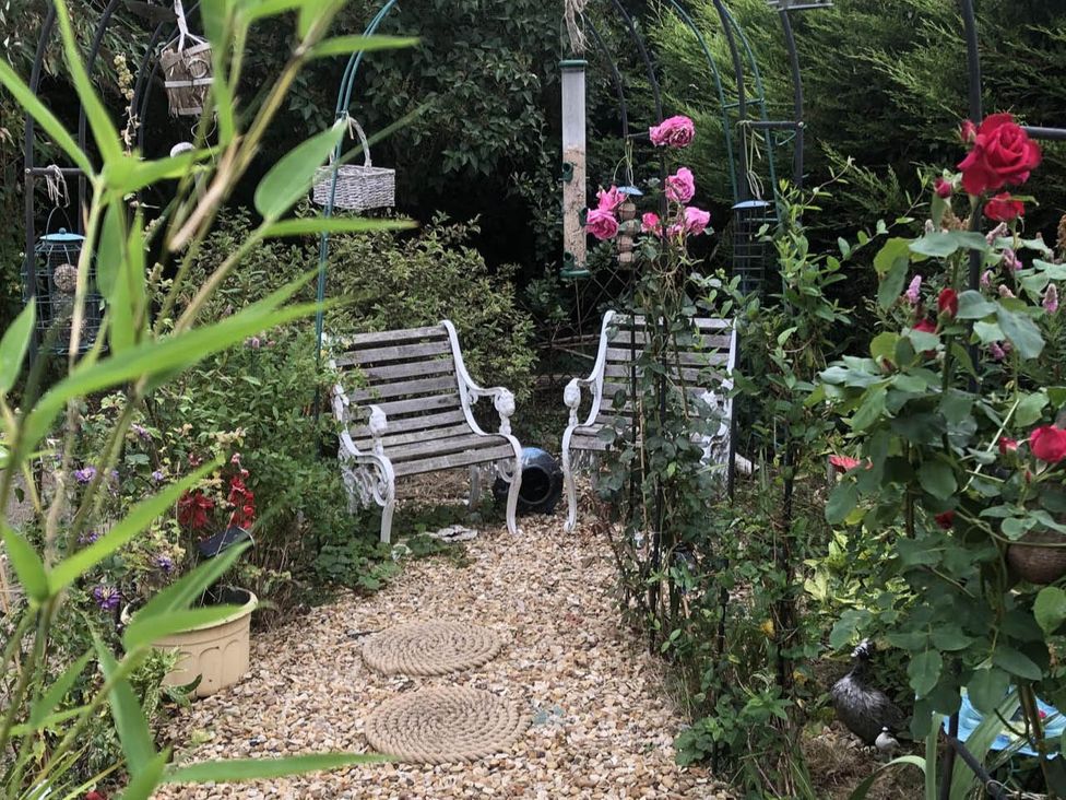 A garden with benches and flowers at Cozy Nook boutique Cottage in Oakham