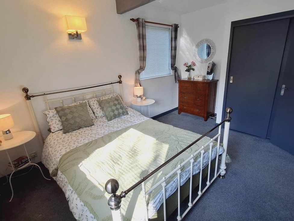 A bedroom with a bed, bedside table, and chest of drawers at Forest Retreat Sleeps 4 2Bed with Parking Woolsery near Bideford