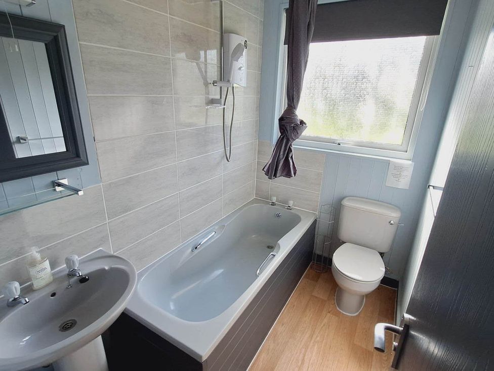 A bathroom with a bathtub, toilet, and sink at Forest Retreat Sleeps 4 2Bed with Parking Woolsery near Bideford