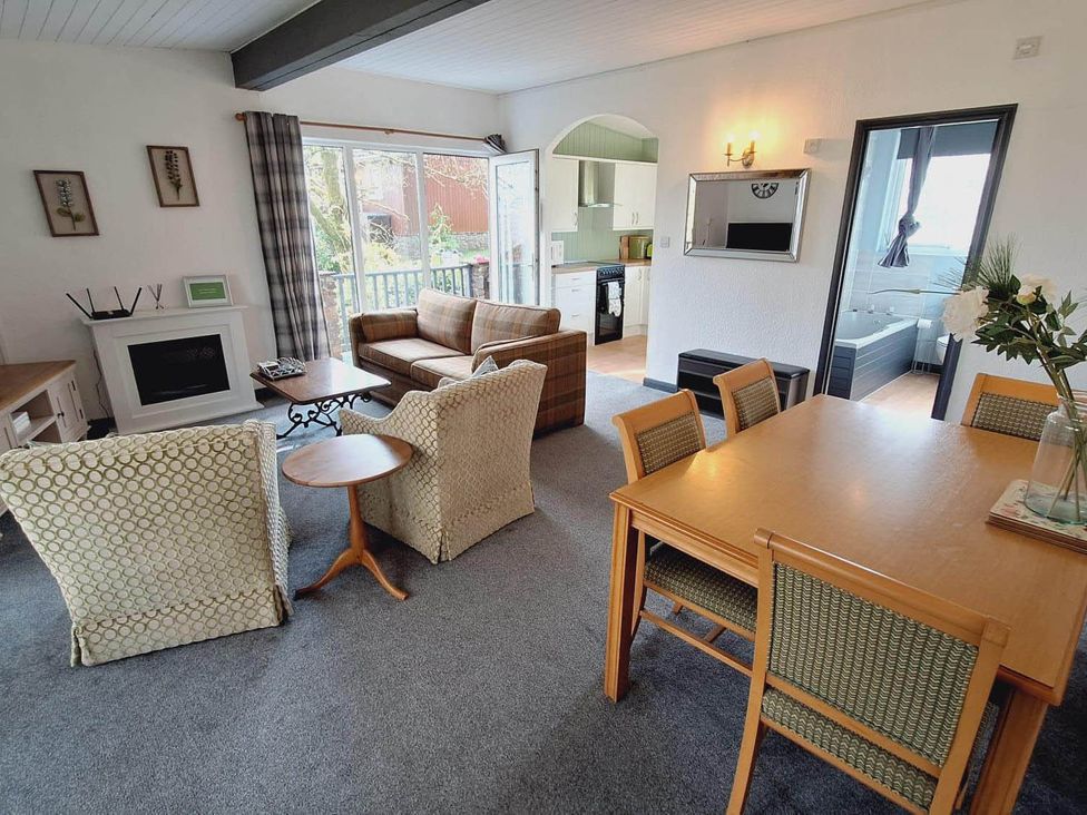 A living room with a sofa, armchairs, and dining table at Forest Retreat Sleeps 4 2Bed with Parking in Woolsery near Bideford