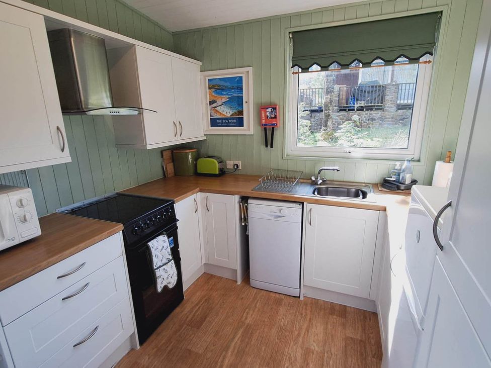 A kitchen with cabinets, oven, sink, and dishwasher at Forest Retreat Sleeps 4 2Bed with Parking Woolsery near Bideford