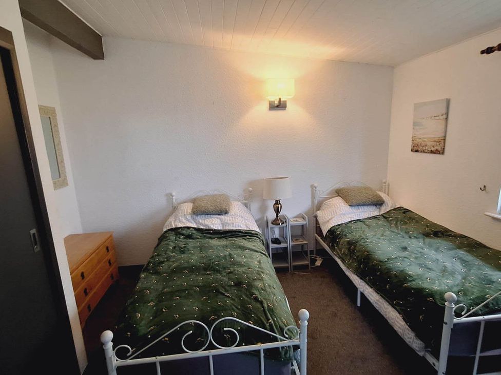 A bedroom with two single beds and a bedside table at Forest Retreat Sleeps 4 2Bed with Parking in Woolsery near Bideford