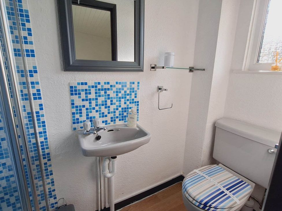 A bathroom with a sink, toilet, and mirror at Forest Retreat Sleeps 4 2Bed with Parking in Woolsery near Bideford