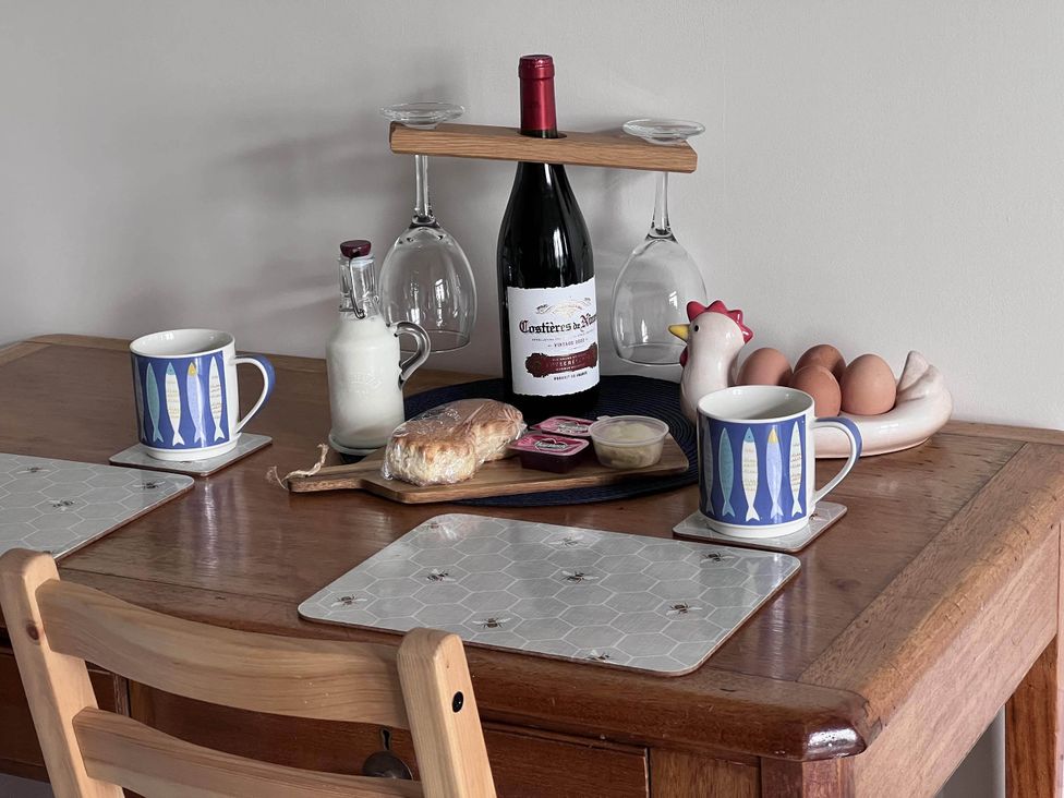 A kitchen table with mugs, milk, wine, bread, eggs, and condiments at Farmhouse Sleeps 5 Near Alton Towers Peak District, Shorwell