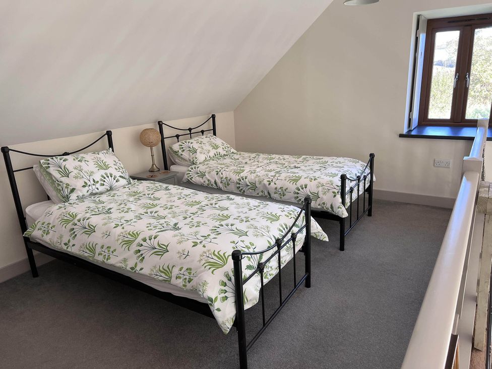 A bedroom with two beds and a lamp at Farmhouse Sleeps 5 Near Alton Towers Peak District in Shorwell