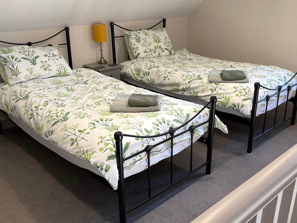 A bedroom with two beds and a lamp at Farmhouse Sleeps 5 Near Alton Towers Peak District in Shorwell