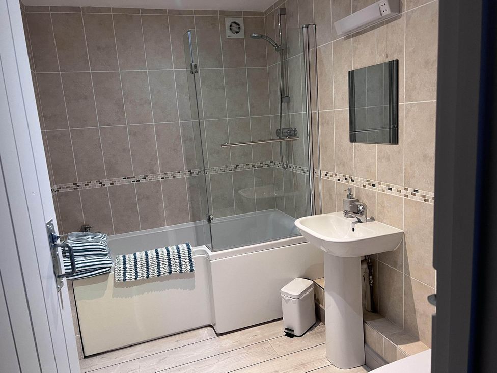A bathroom featuring a bath tub, shower area, sink, and mirror at Farmhouse Sleeps 5 Near Alton Towers Peak District, Shorwell